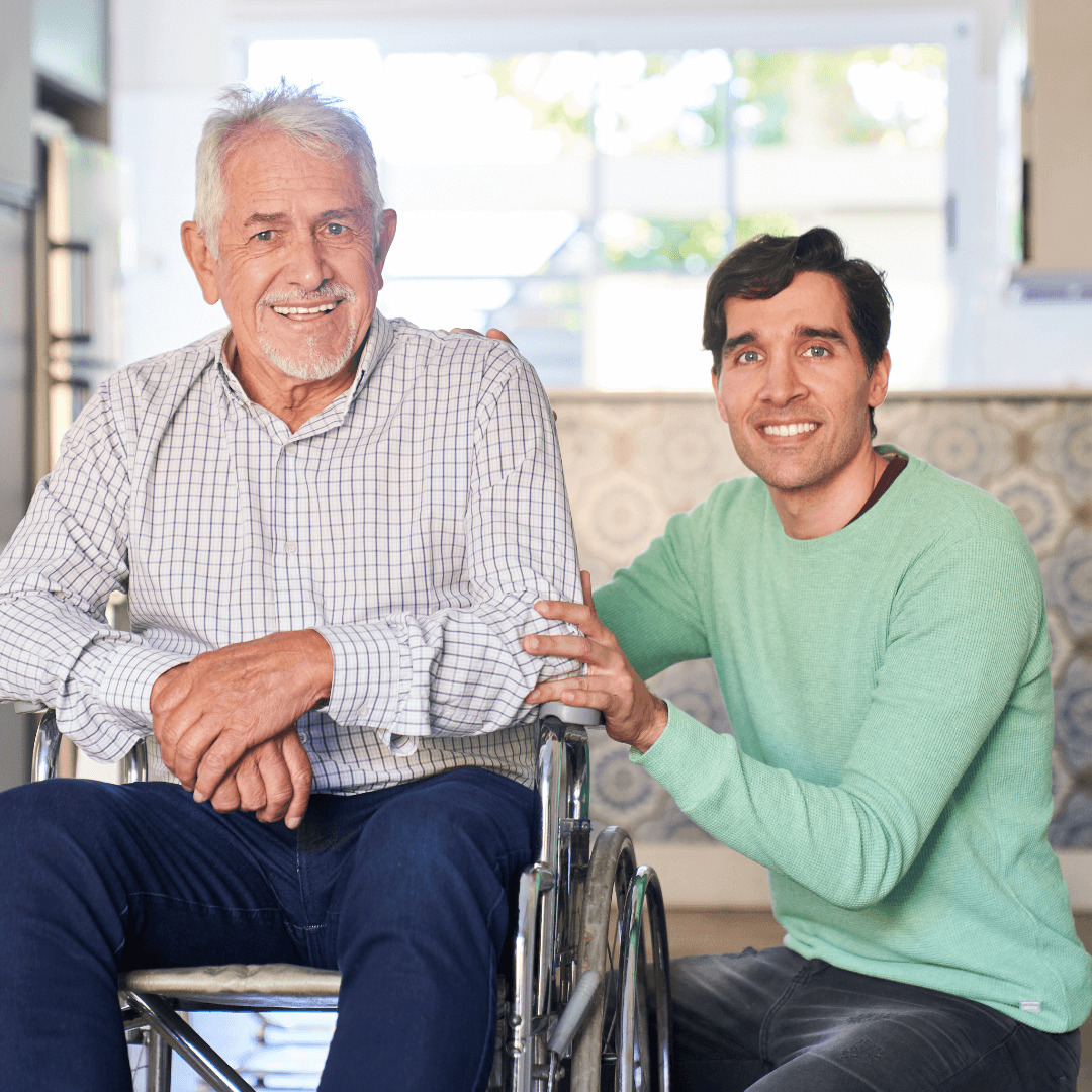 Always Family - a young man kneeling next to an elderly man in a wheelchair