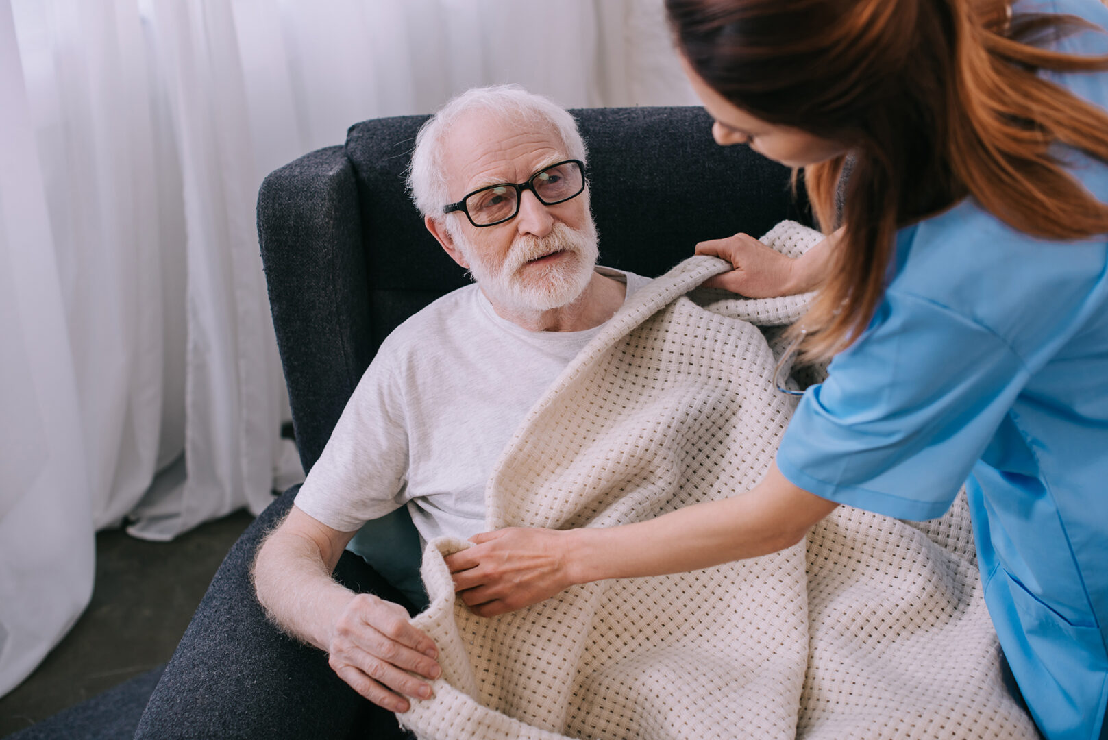 A caregiver helping a senior man