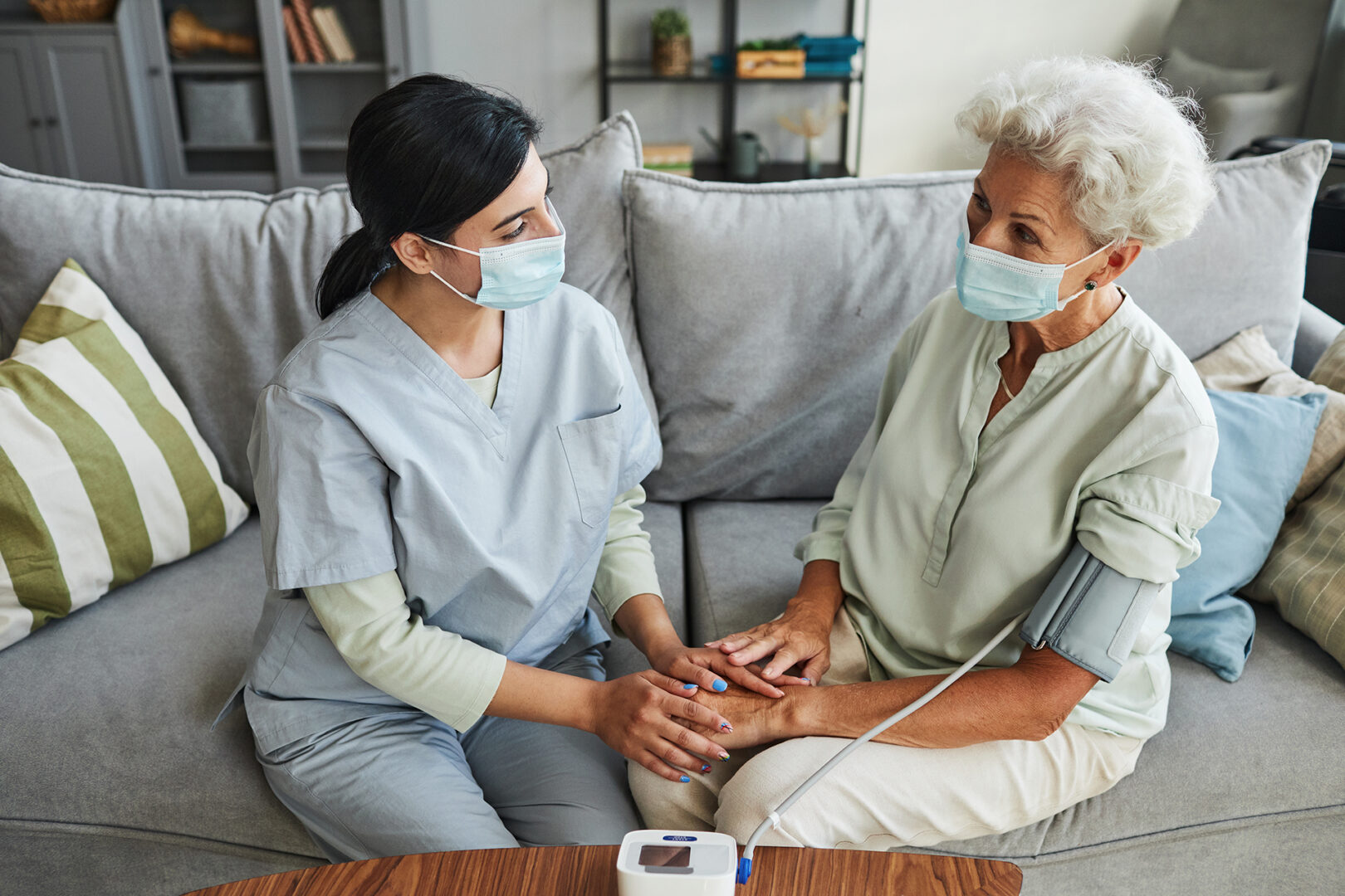 A caregiver checking blood-pressure to a senior woman
