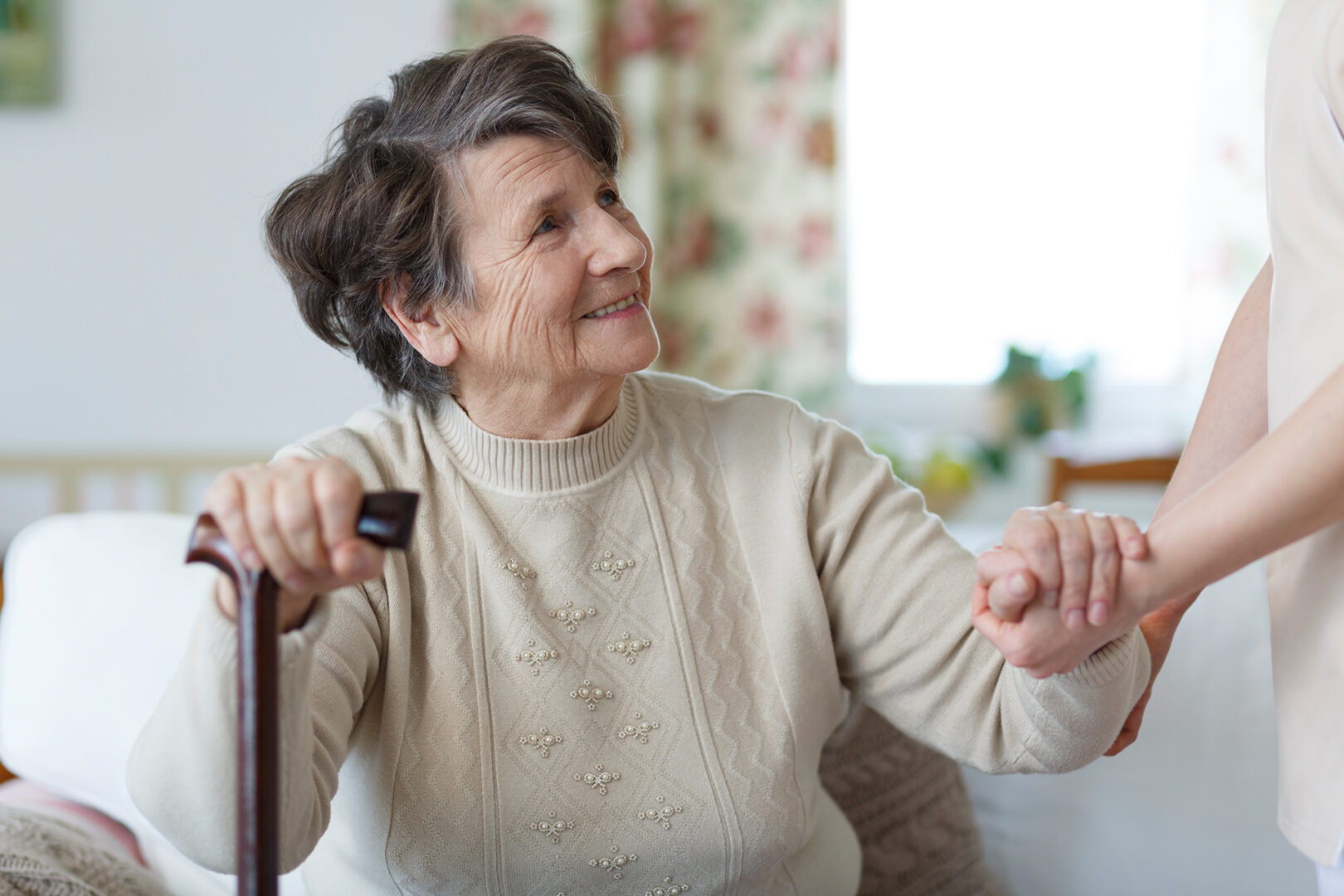 A happy senior woman looking at her caregiver