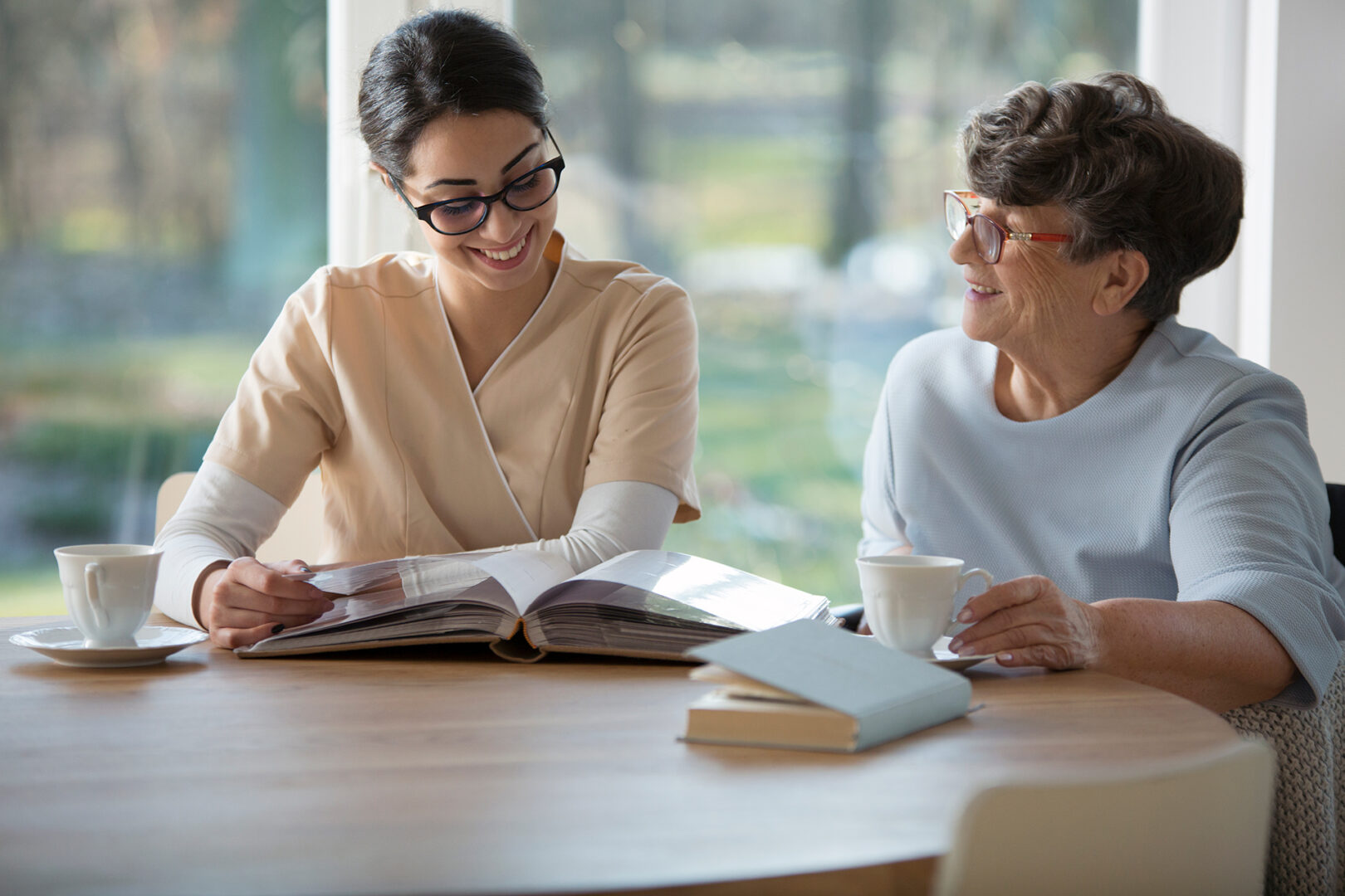 A caregiver reading to a senior woman