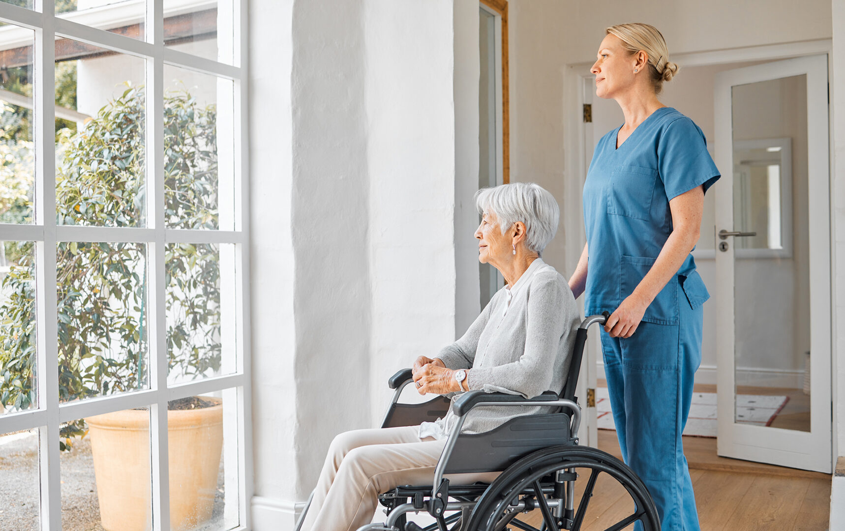 A senior woman in a wheelchair looking outside